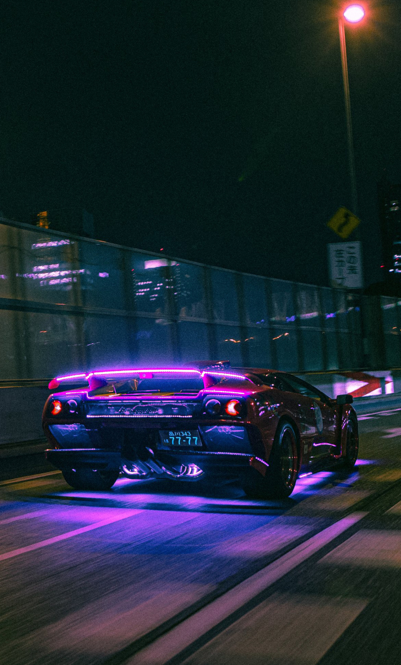 A car driving down the street at night - Neon