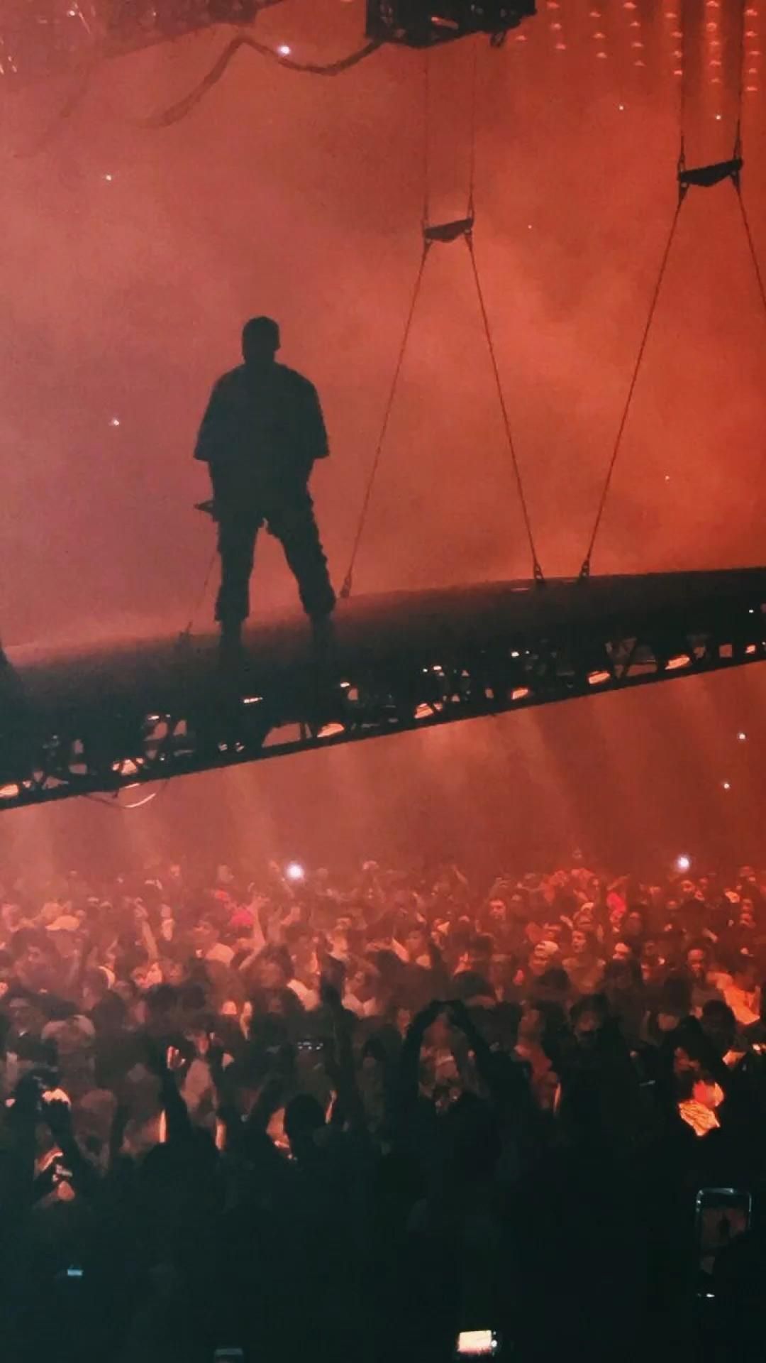 Kanye West performing on a floating platform at a concert - Kanye West