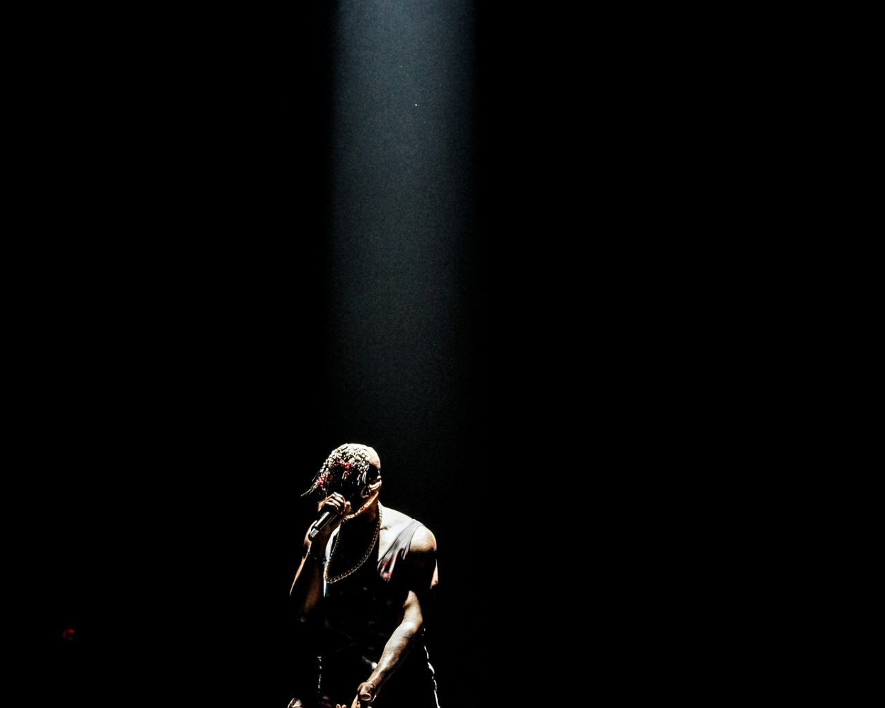 A man is standing on stage with his guitar - Kanye West