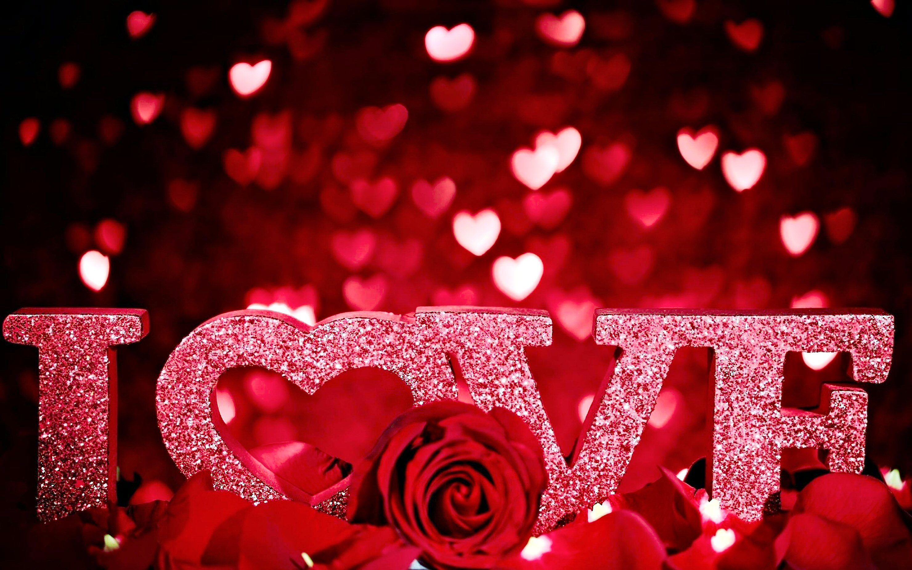 The word love is written in red letters with hearts and roses - Valentine's Day