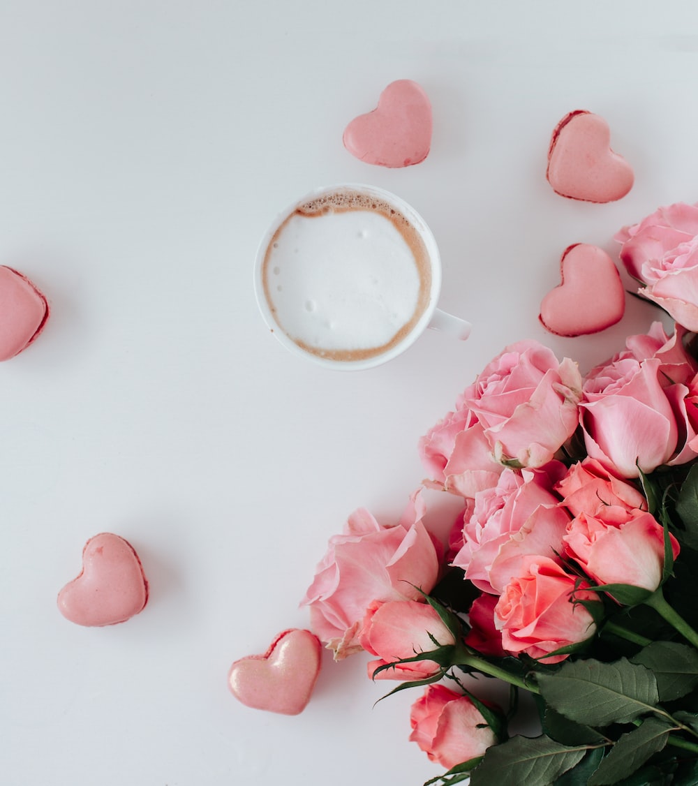 A cup of coffee with pink roses and heart shaped cookies - Valentine's Day