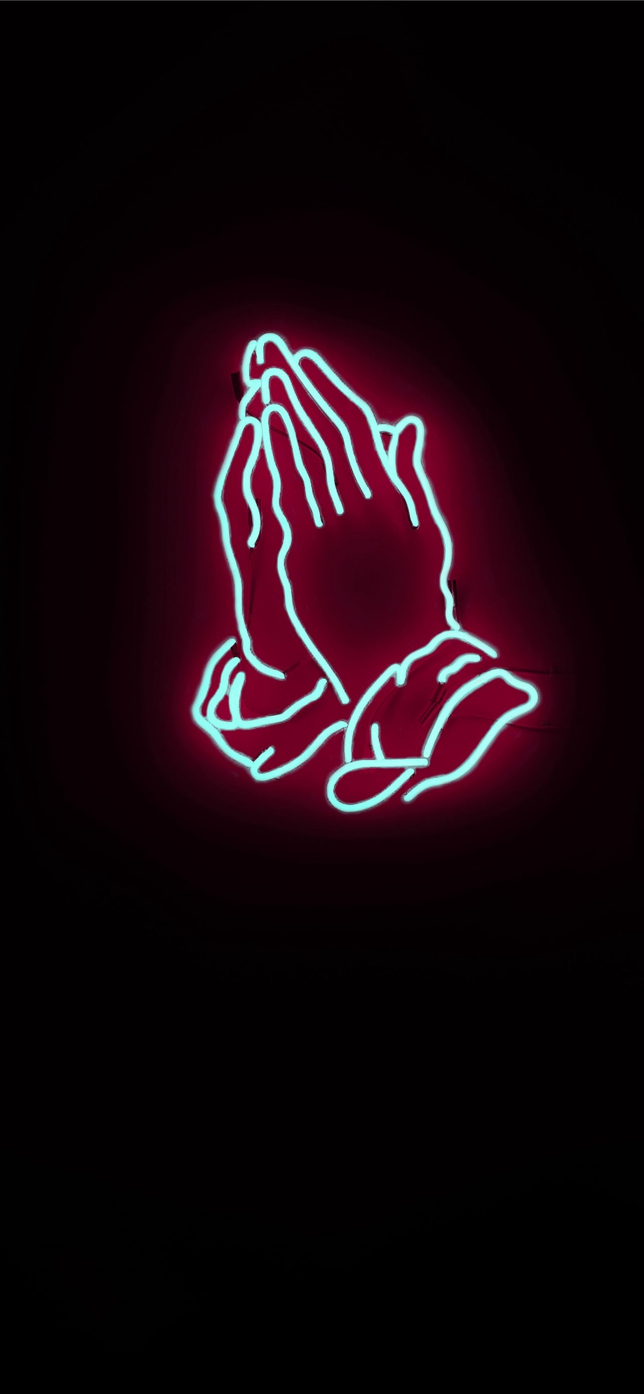 A neon sign of two hands in a praying position - Jesus