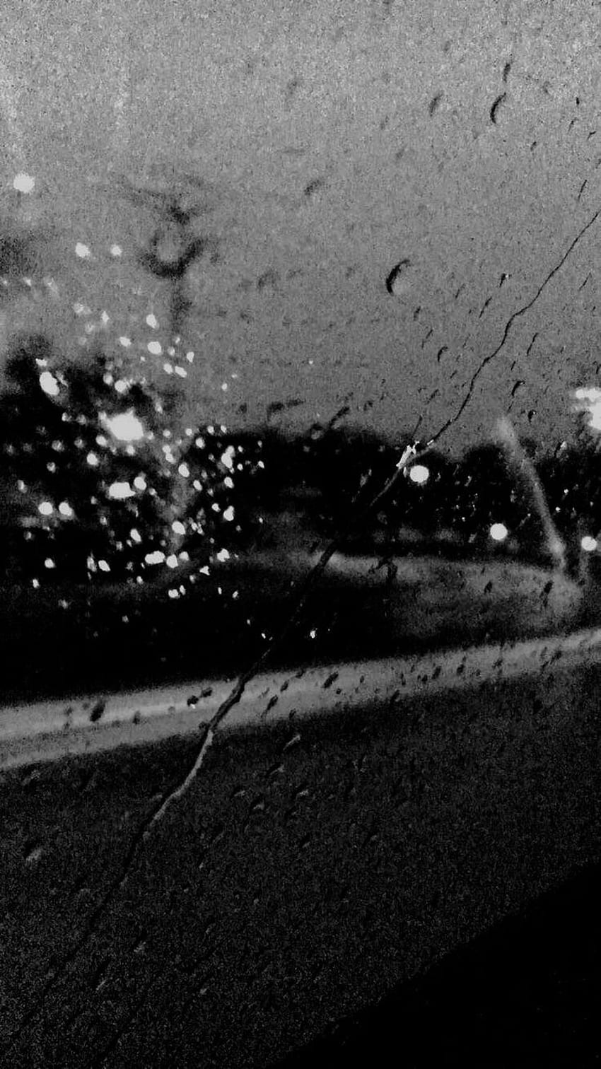 A black and white photo of a rain-covered window. - Rain