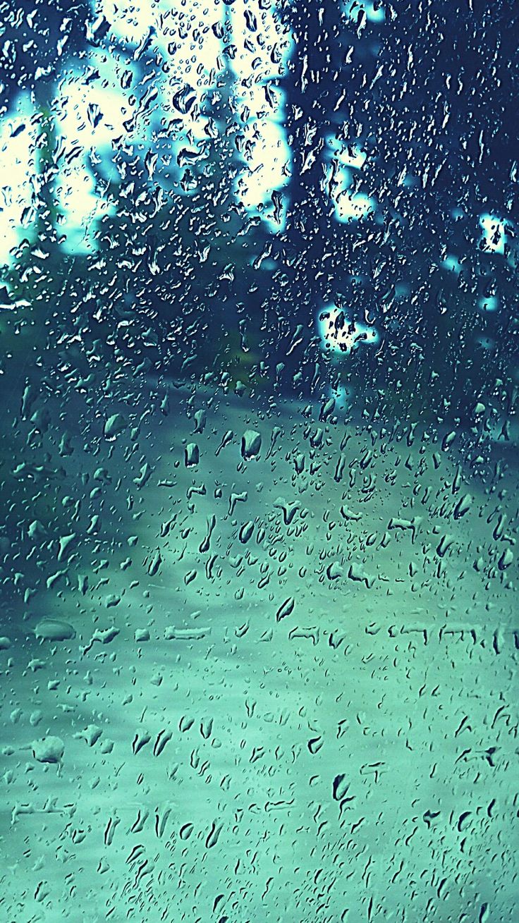 Raindrops on a window with a blue and green background - Rain