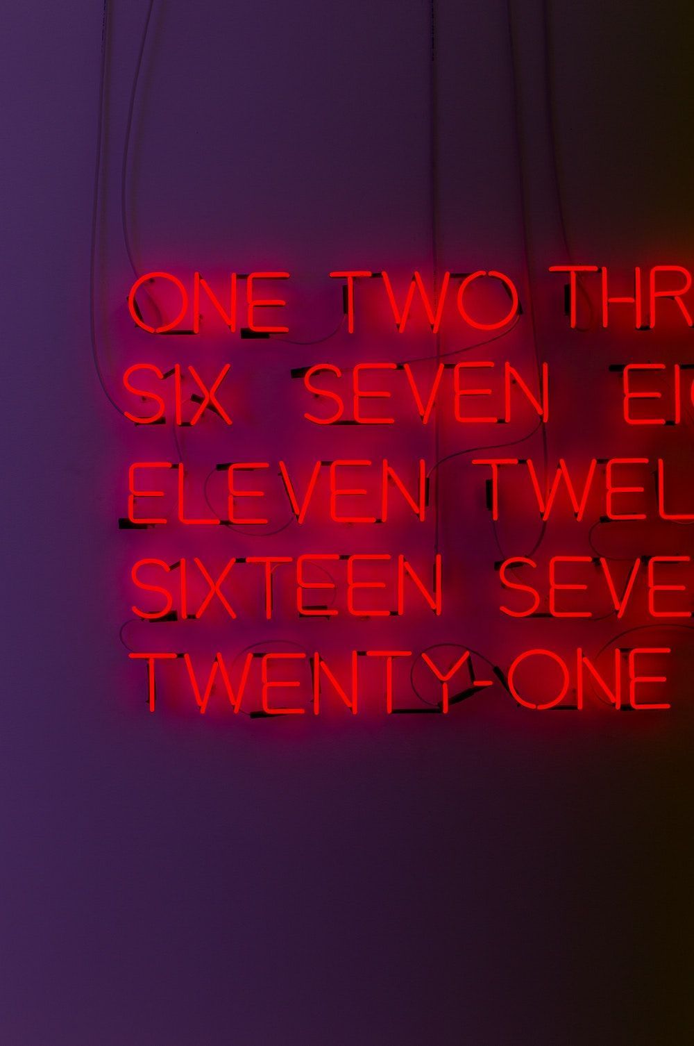 A red neon sign with the numbers of a clock. - Dark red
