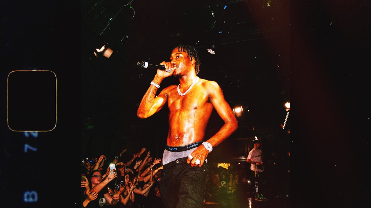 A man singing on stage with his shirt off - XXXTentacion