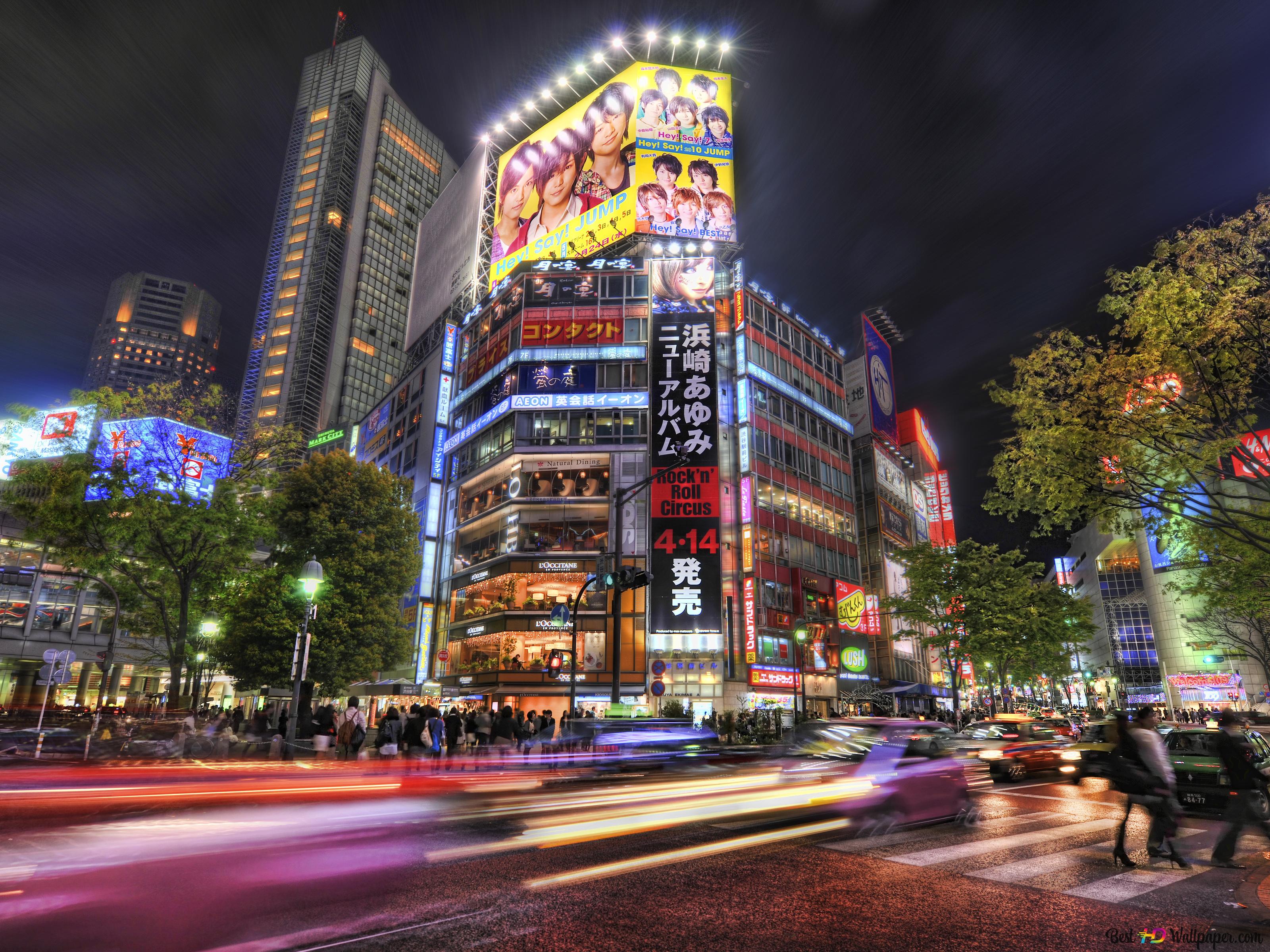 A busy street in Tokyo at night with many lights and people. - Tokyo