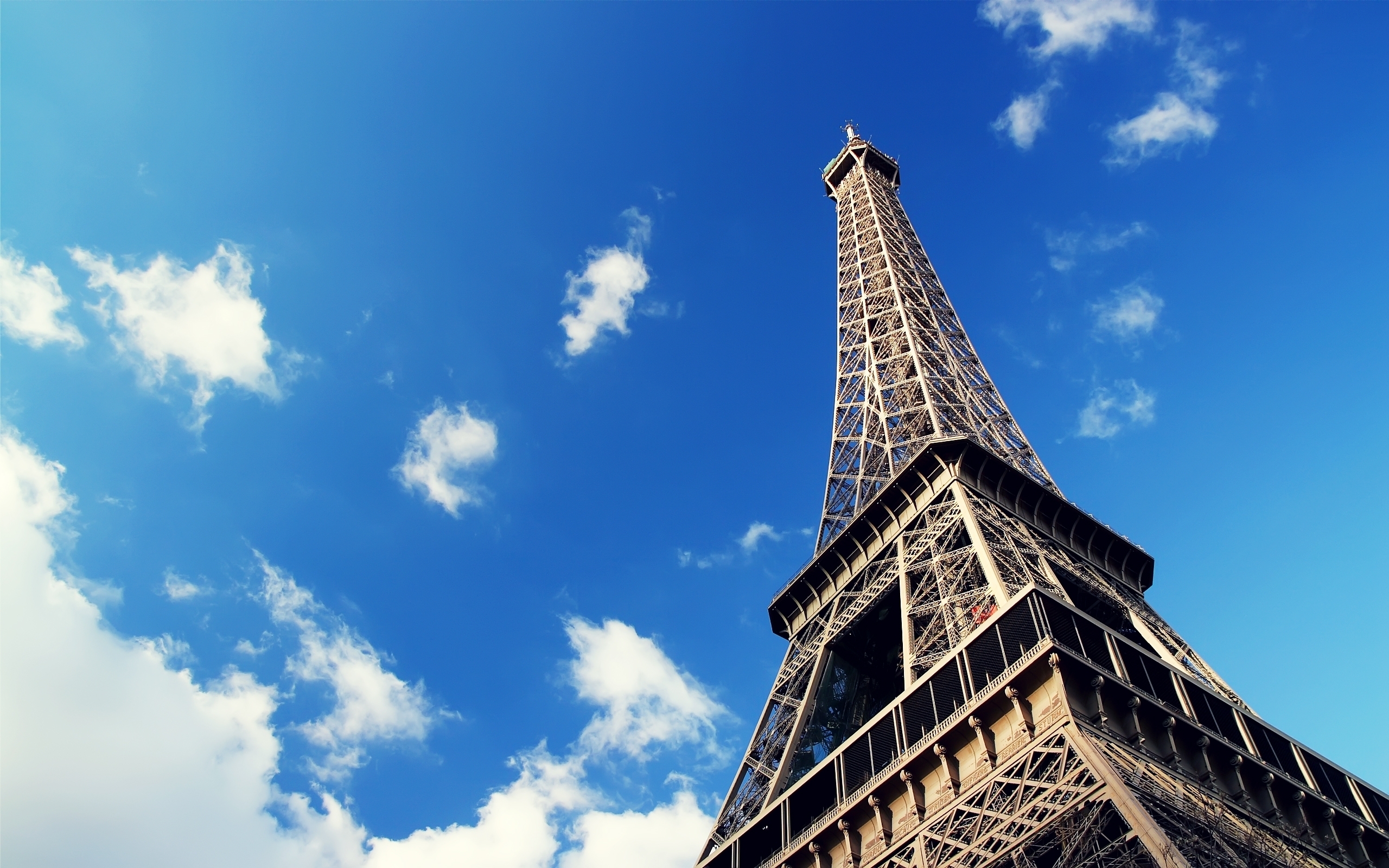 The eiffel tower is shown against a blue sky - Paris