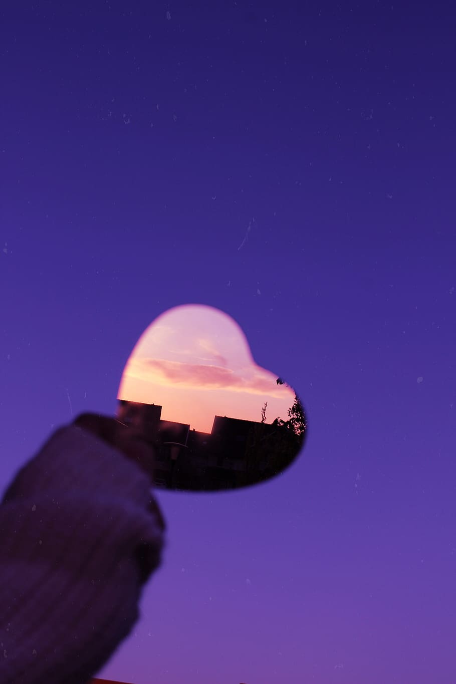 A heart-shaped mirror reflecting a sunset sky - Neon orange