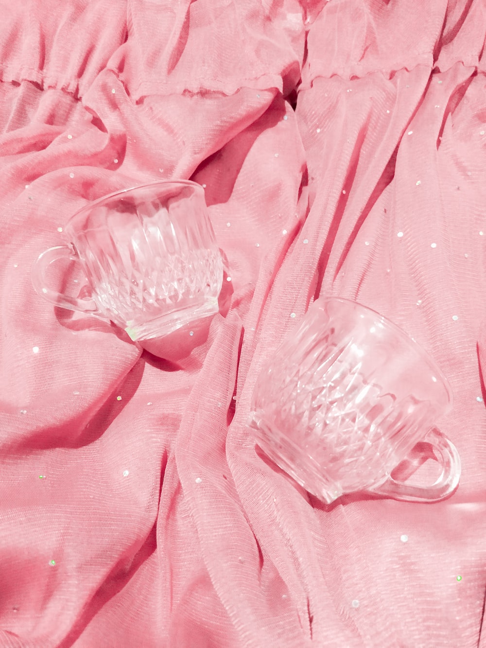 Two glasses sitting on a pink tablecloth - Soft pink