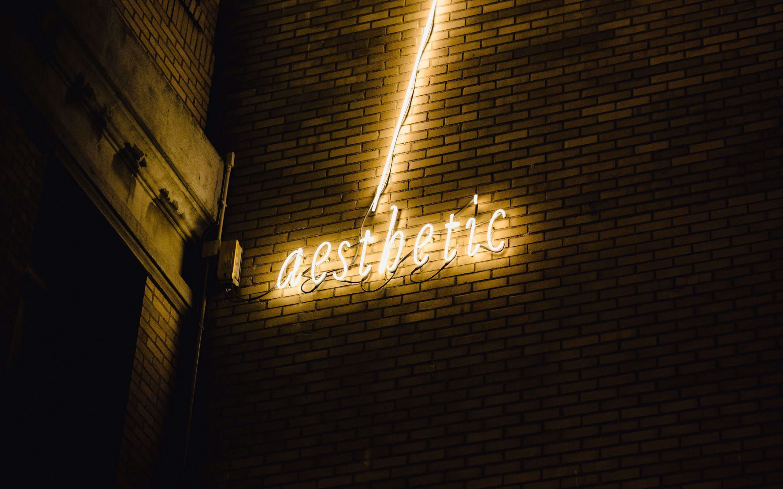 A neon sign on the side of building - 2560x1600