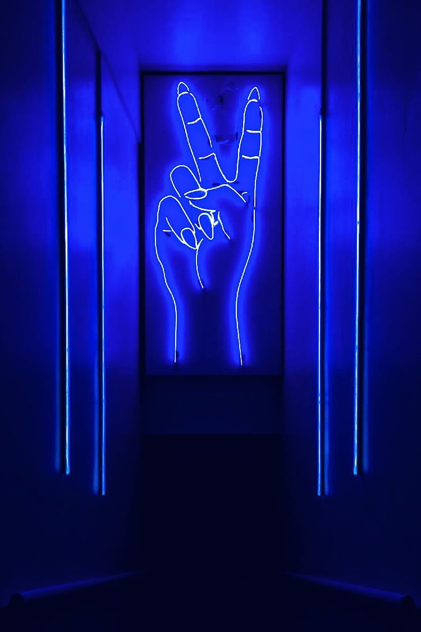 A neon sign of a hand making the peace sign - Peace