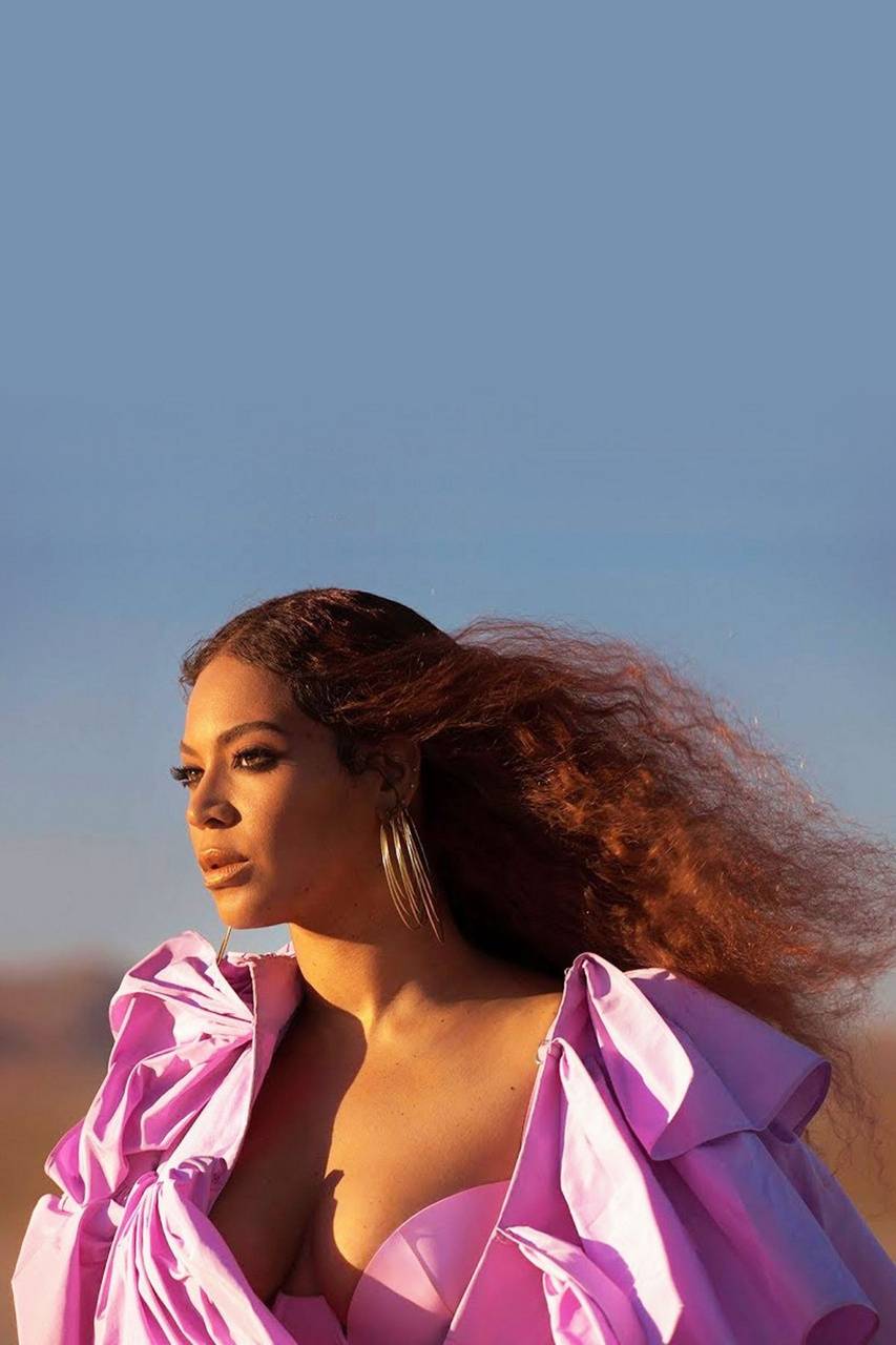 A woman in pink standing on the desert - Beyonce