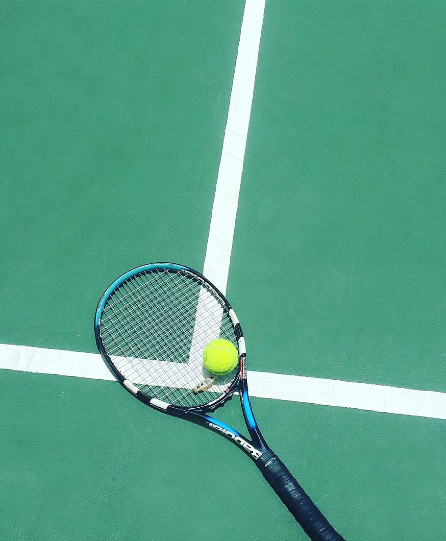 Tennis ball on a racket on the court - Tennis