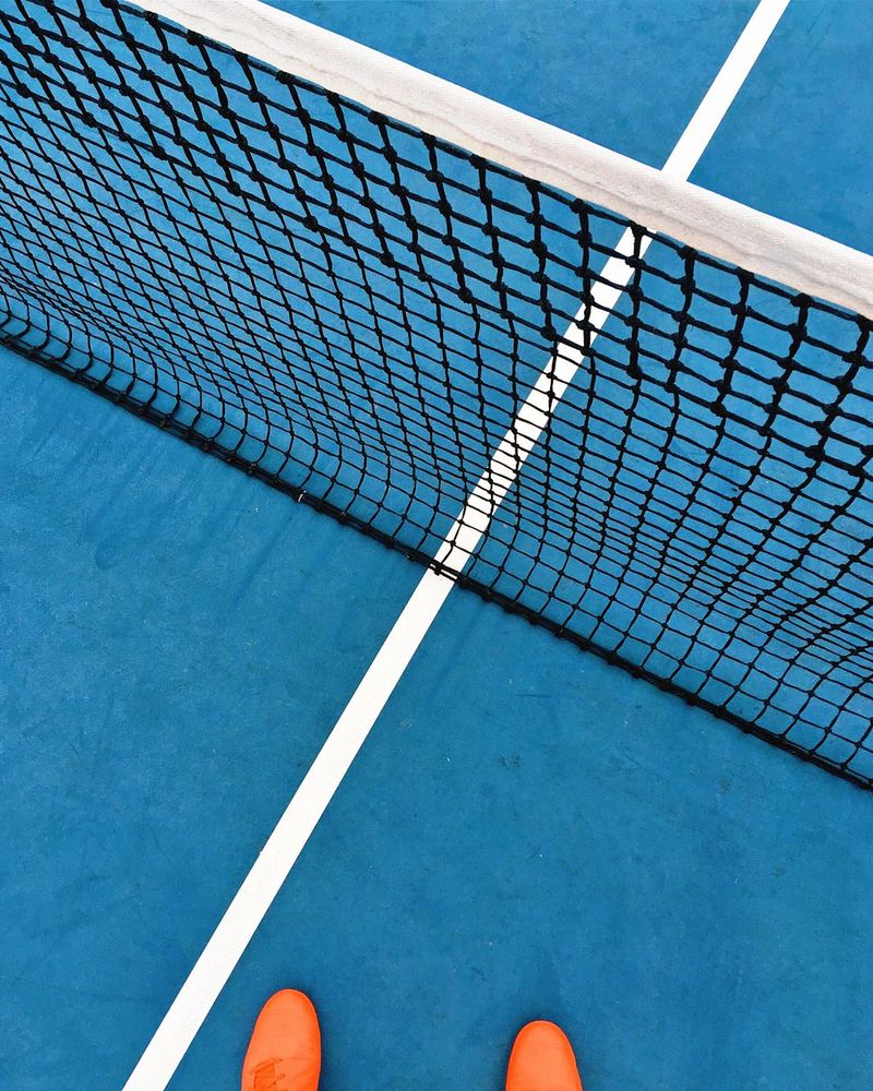 A person standing on top of tennis court - Tennis