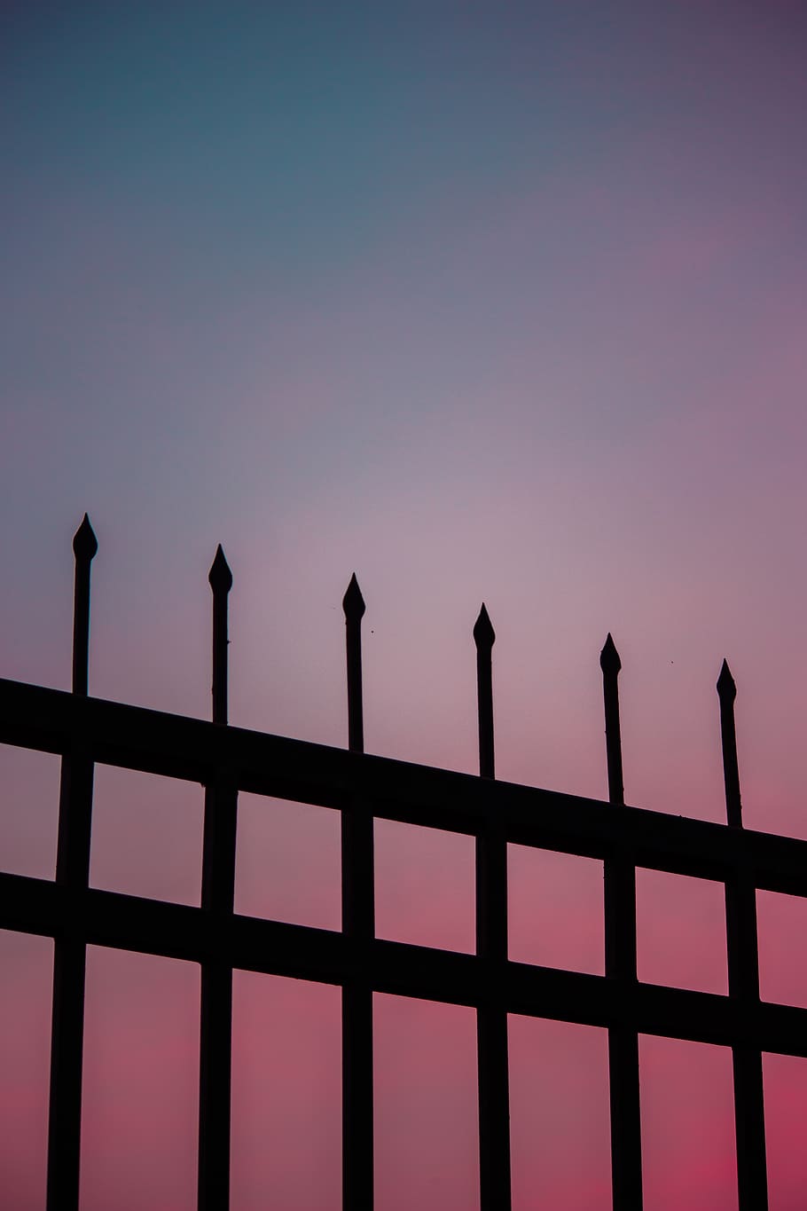 Silhouette of a fence against a pink and blue sky - Pastel minimalist
