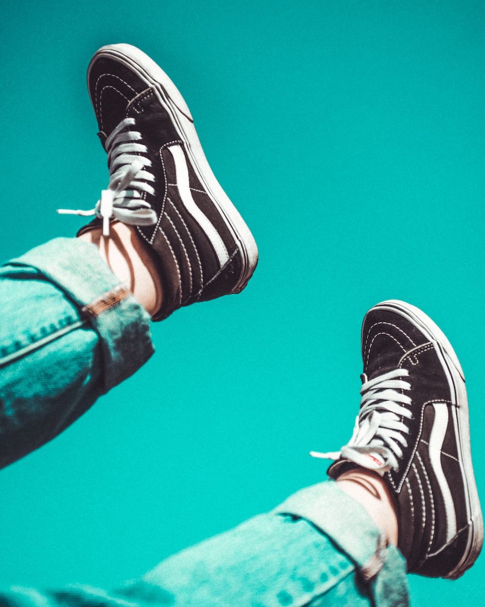 A person is in the air with their shoes on - Vans