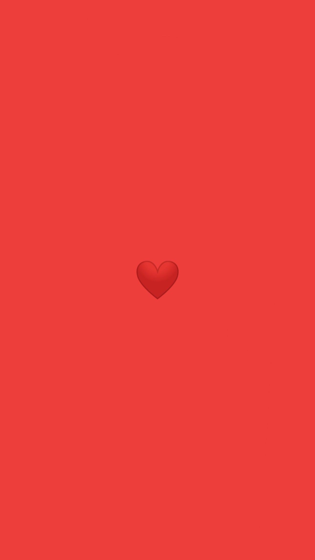 A red background with a small red heart in the middle - Emoji