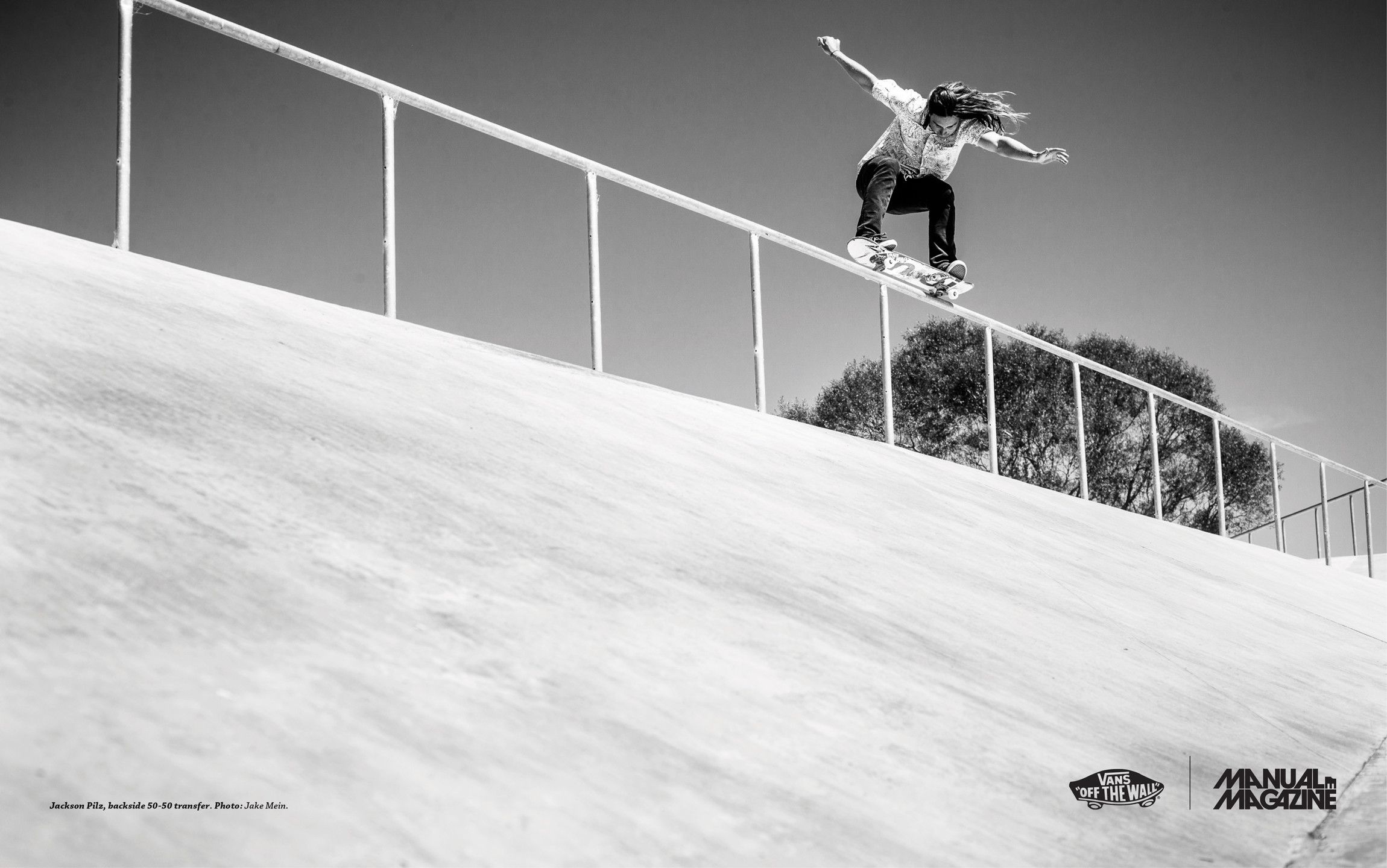 A person on a skateboard does a trick on a rail. - Vans