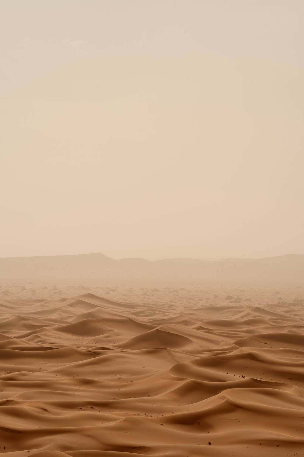 A desert landscape with sand dunes and a hazy sky - Desert