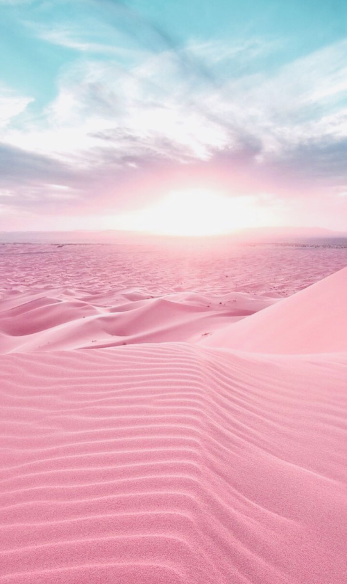 A pink sand dune with blue sky in the background - Desert