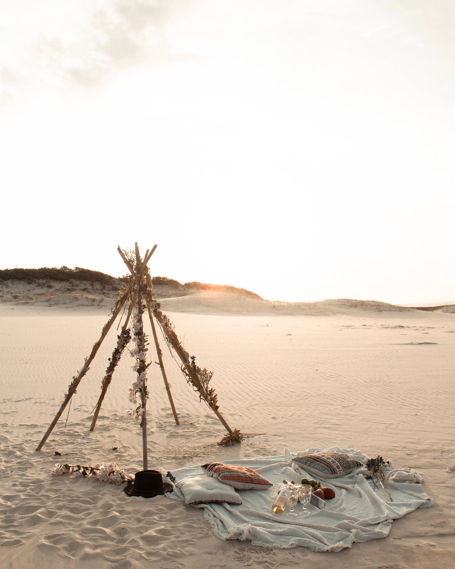 A beach teepee with a blanket and pillows set up for a beach picnic - Desert