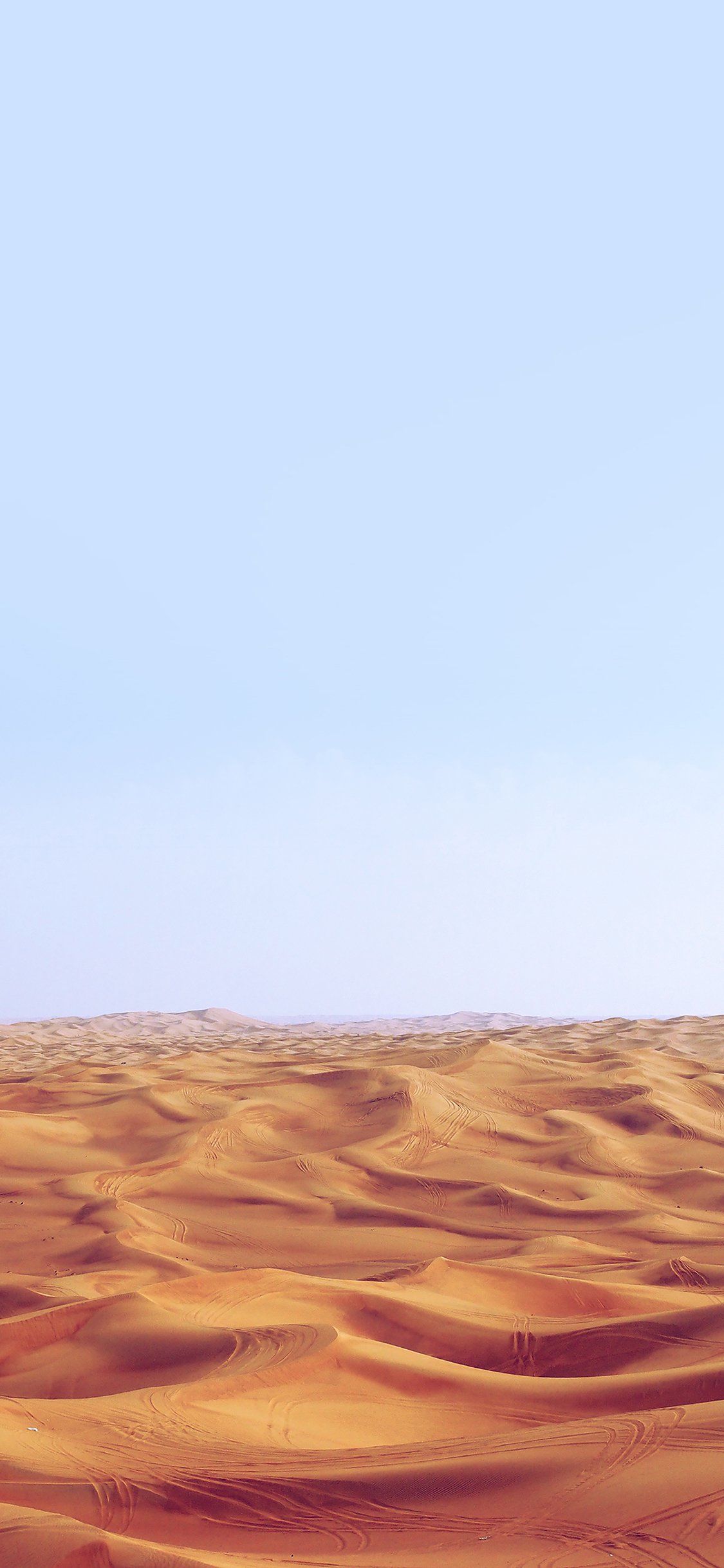 A desert landscape with sand dunes and a blue sky - Desert