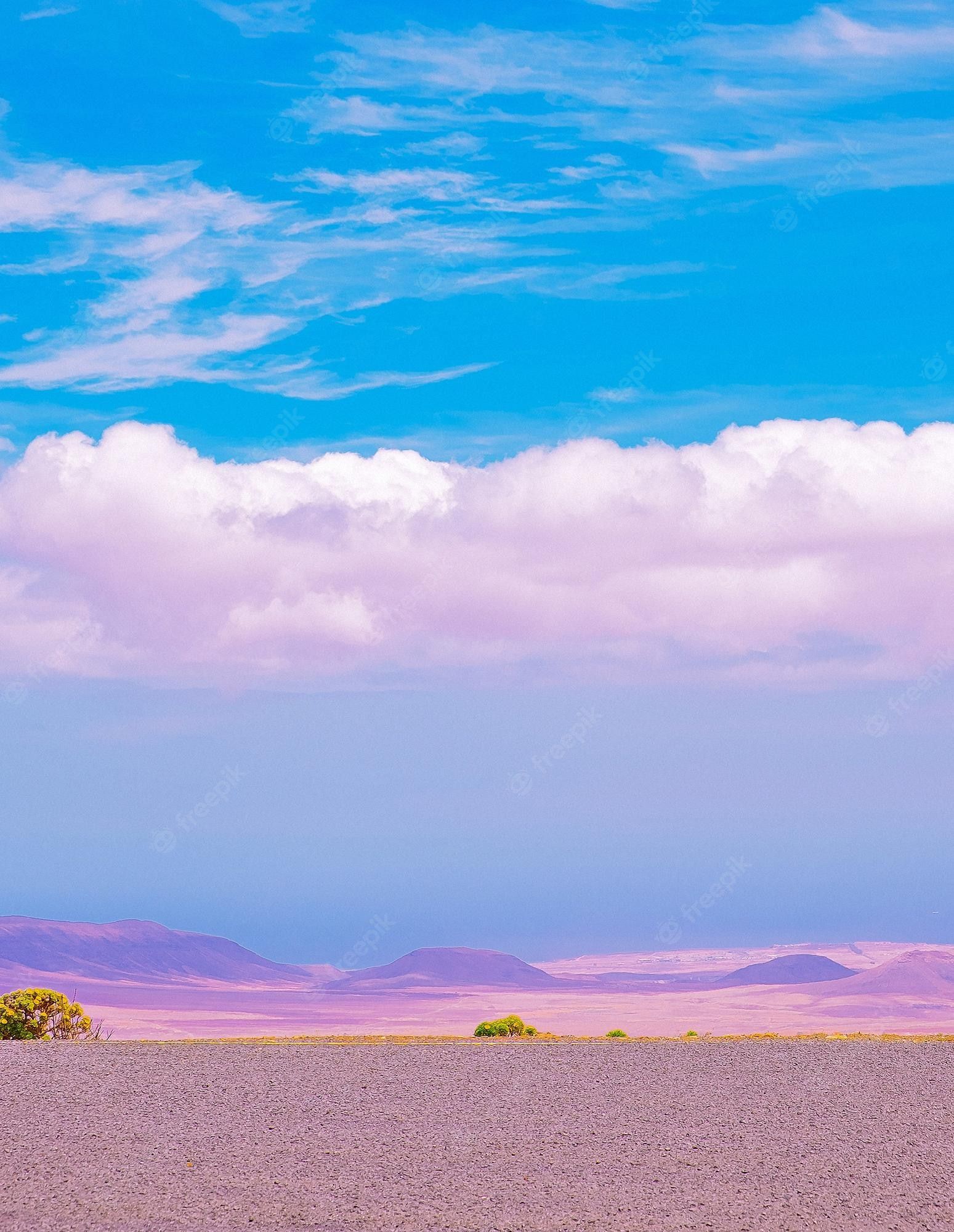 A desert landscape with a blue sky and clouds - Desert