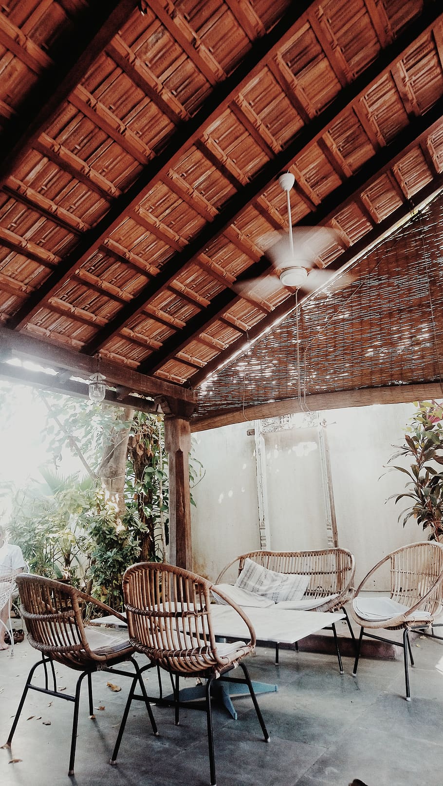 A patio with wicker furniture and plants - Warm