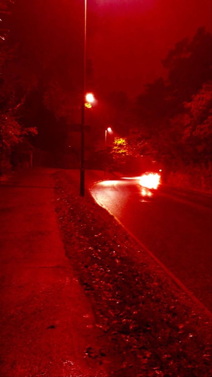 A street light shines red in the night - Light red
