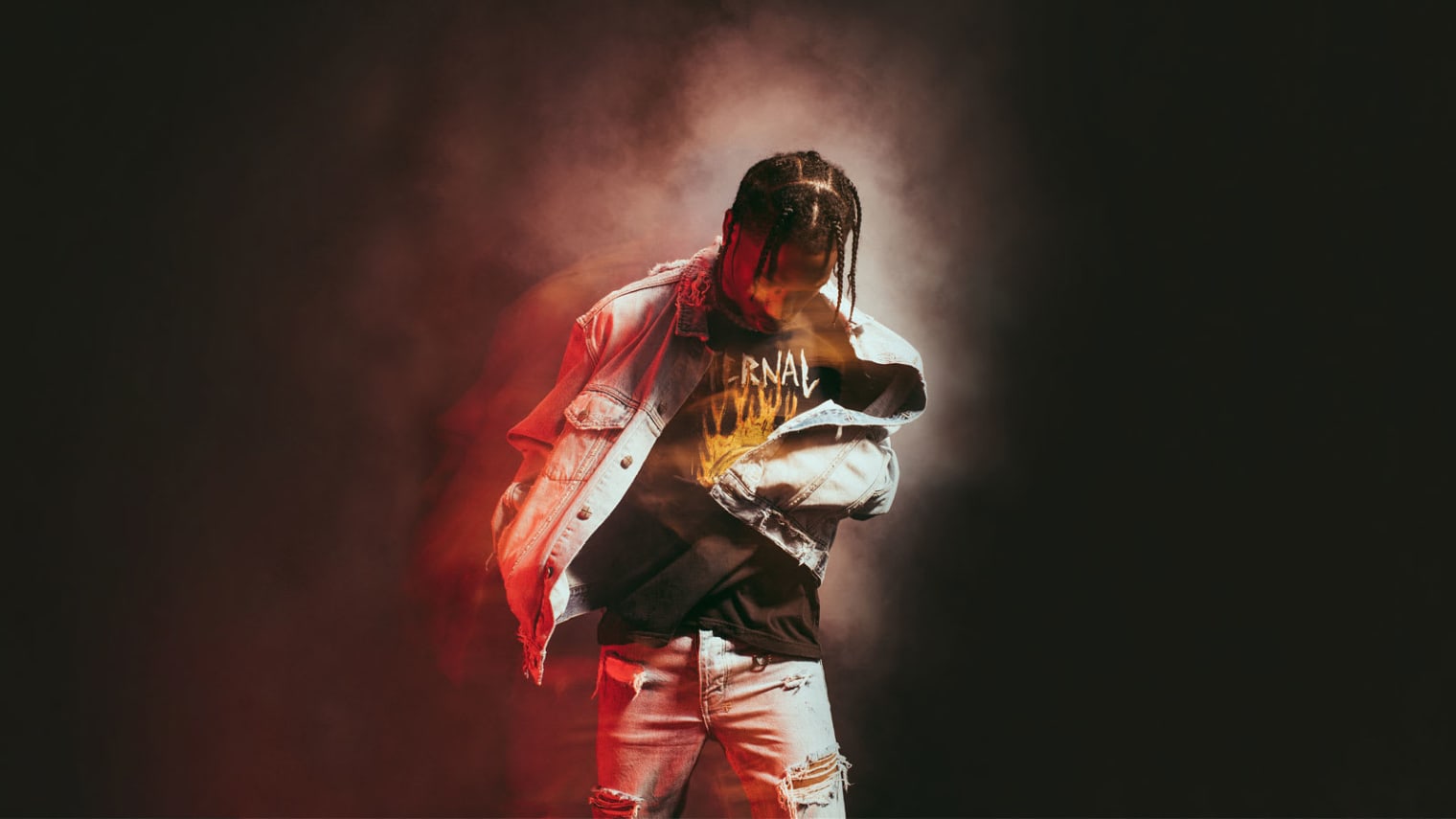 Travis Scott standing in a white jacket and white jeans with a black background and red smoke - Travis Scott