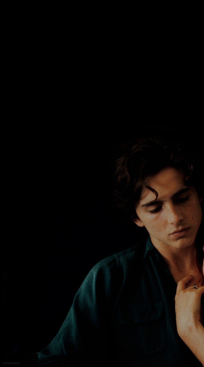 Aesthetic wallpaper of a man in a green shirt against a black background - Timothee Chalamet