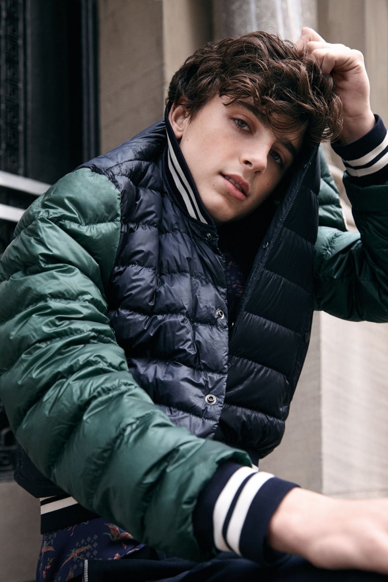 A young man in an outfit is sitting on the ground - Timothee Chalamet