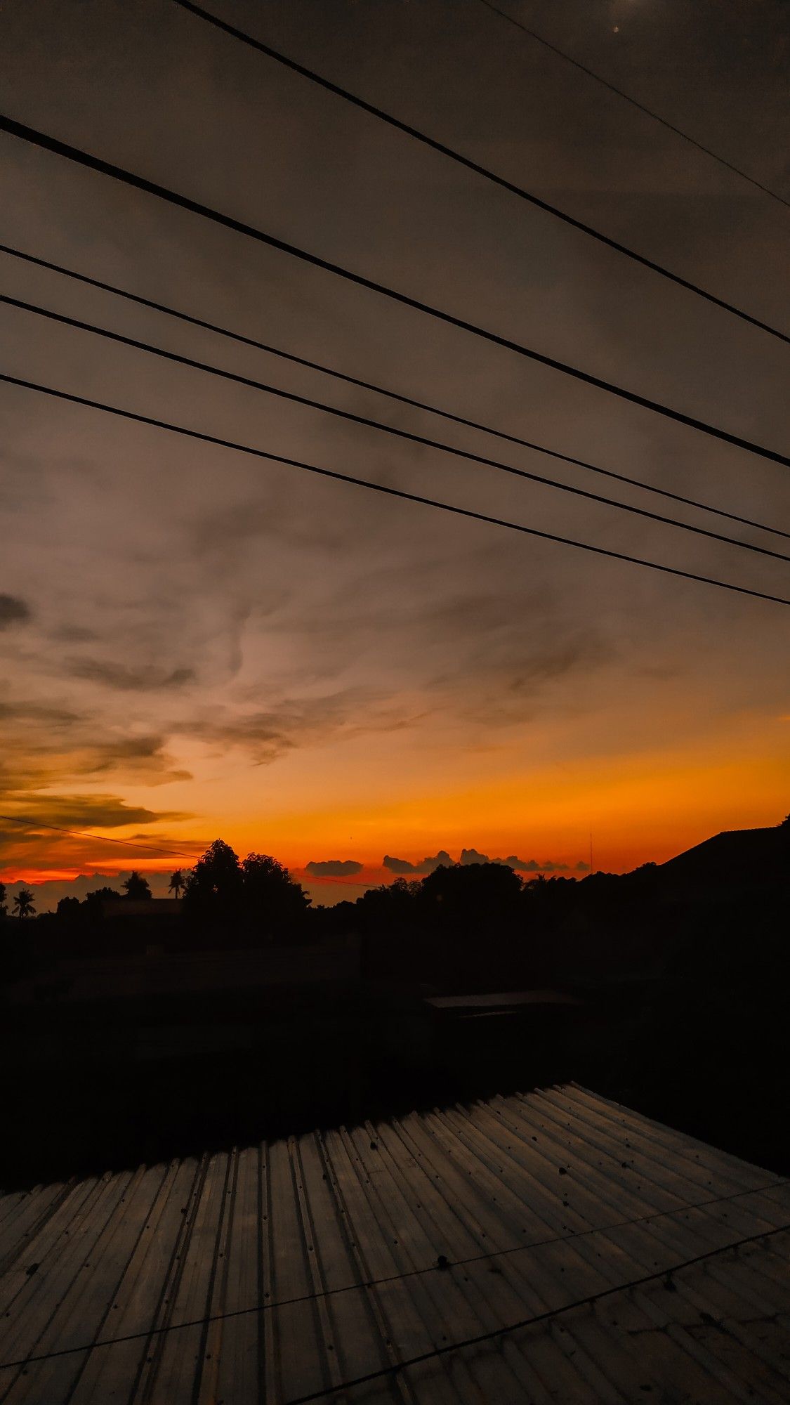 A beautiful sunset over a wooden deck with power lines above. - Sunrise