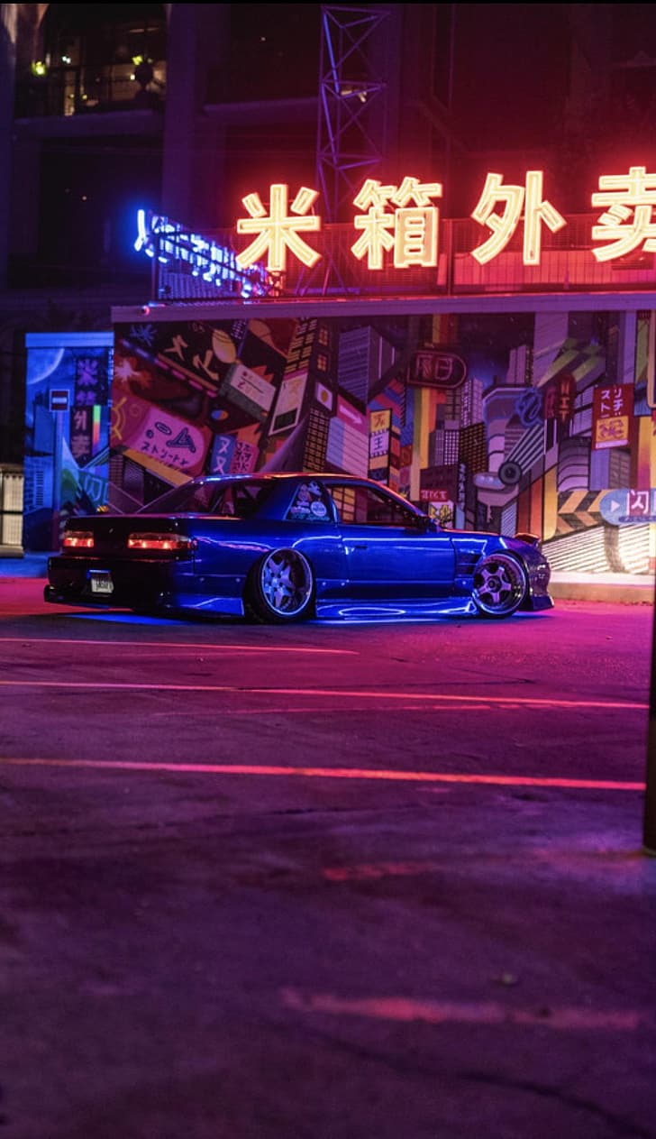 A car parked in front of an asian sign - Japanese, cars