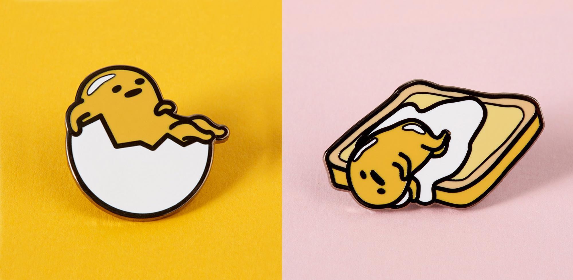 Two Gudetama enamel pins, one of him hatching from an egg and one of him sleeping on a piece of toast. - Gudetama