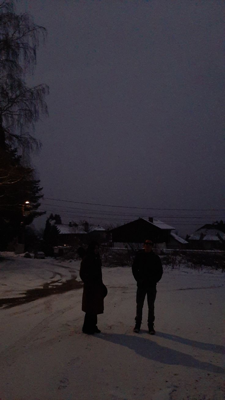 A couple of people standing in the snow - Winter