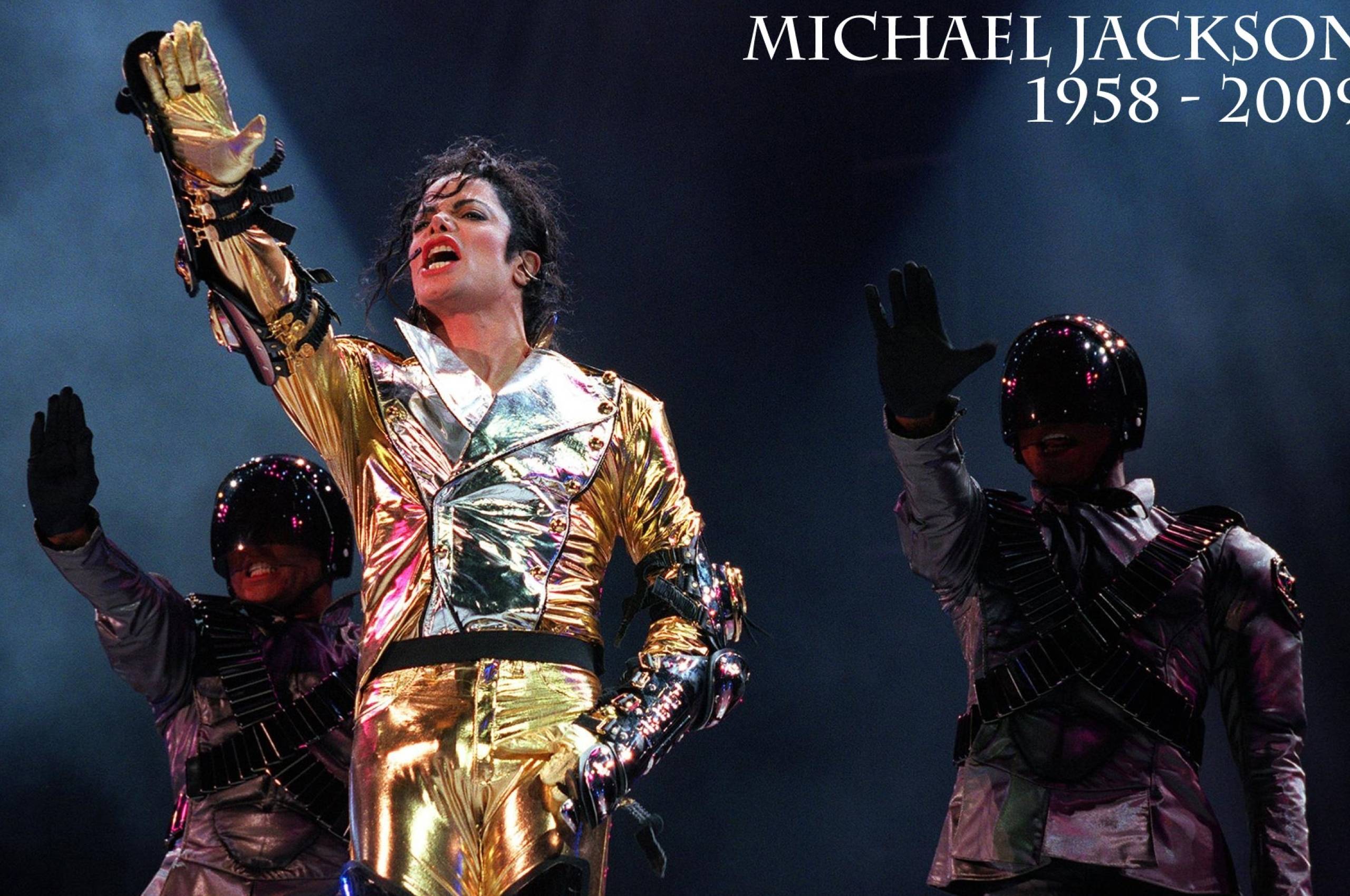 Michael Jackson performs on stage in a gold suit. - Michael Jackson