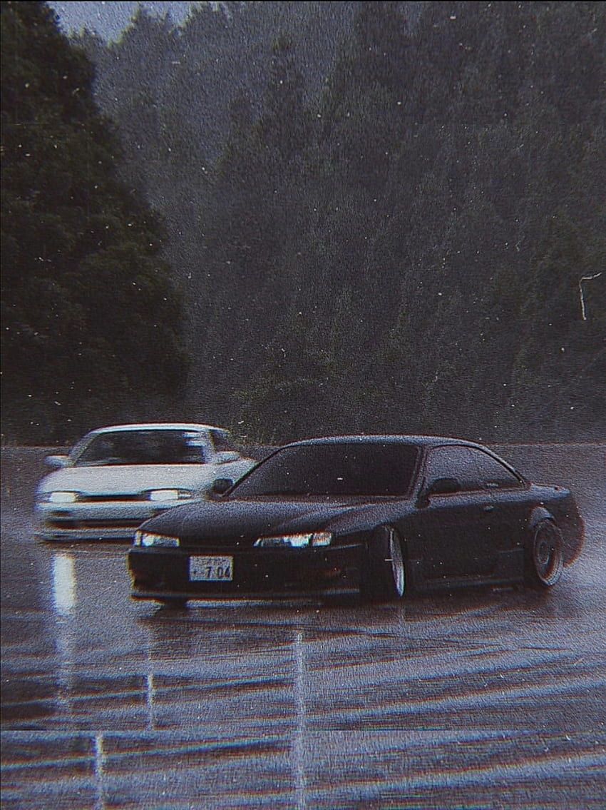A couple of cars driving in the rain - JDM
