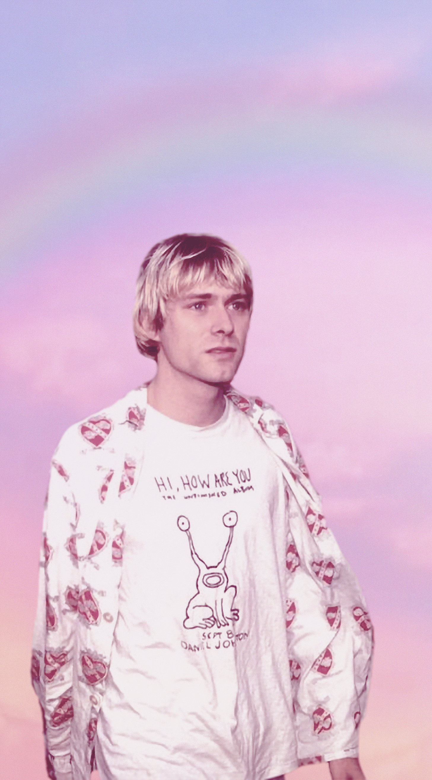 A man with blonde hair and a white shirt with a cartoon alien on it stands in front of a pink and blue gradient background. - Nirvana