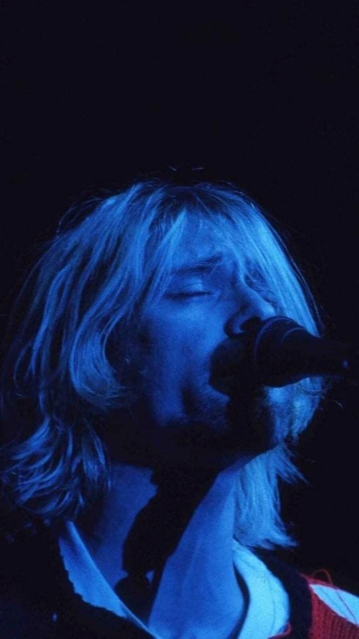 A wallpaper of kurt cobain singing into a microphone with a blue hue - Nirvana