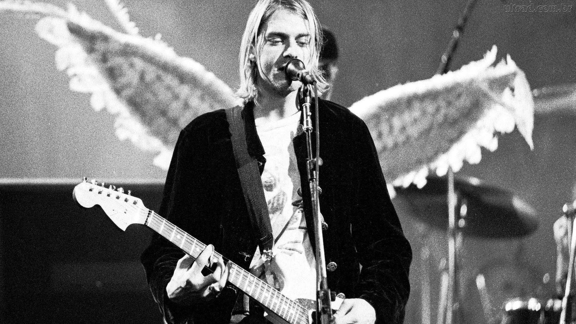 A black and white photo of person playing guitar - Nirvana