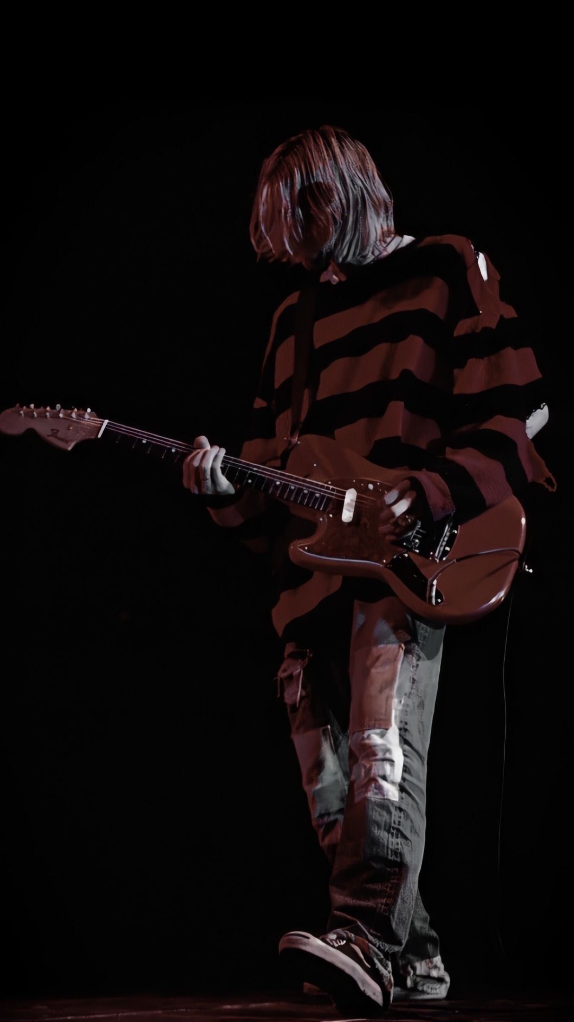 A man playing an electric guitar in the dark - Nirvana