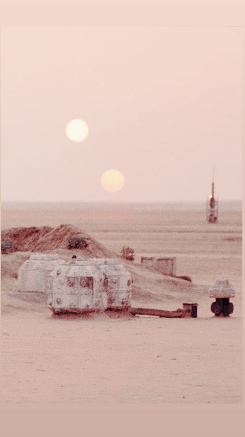 A desert scene with a double sunset and a small building in the foreground. - Star Wars