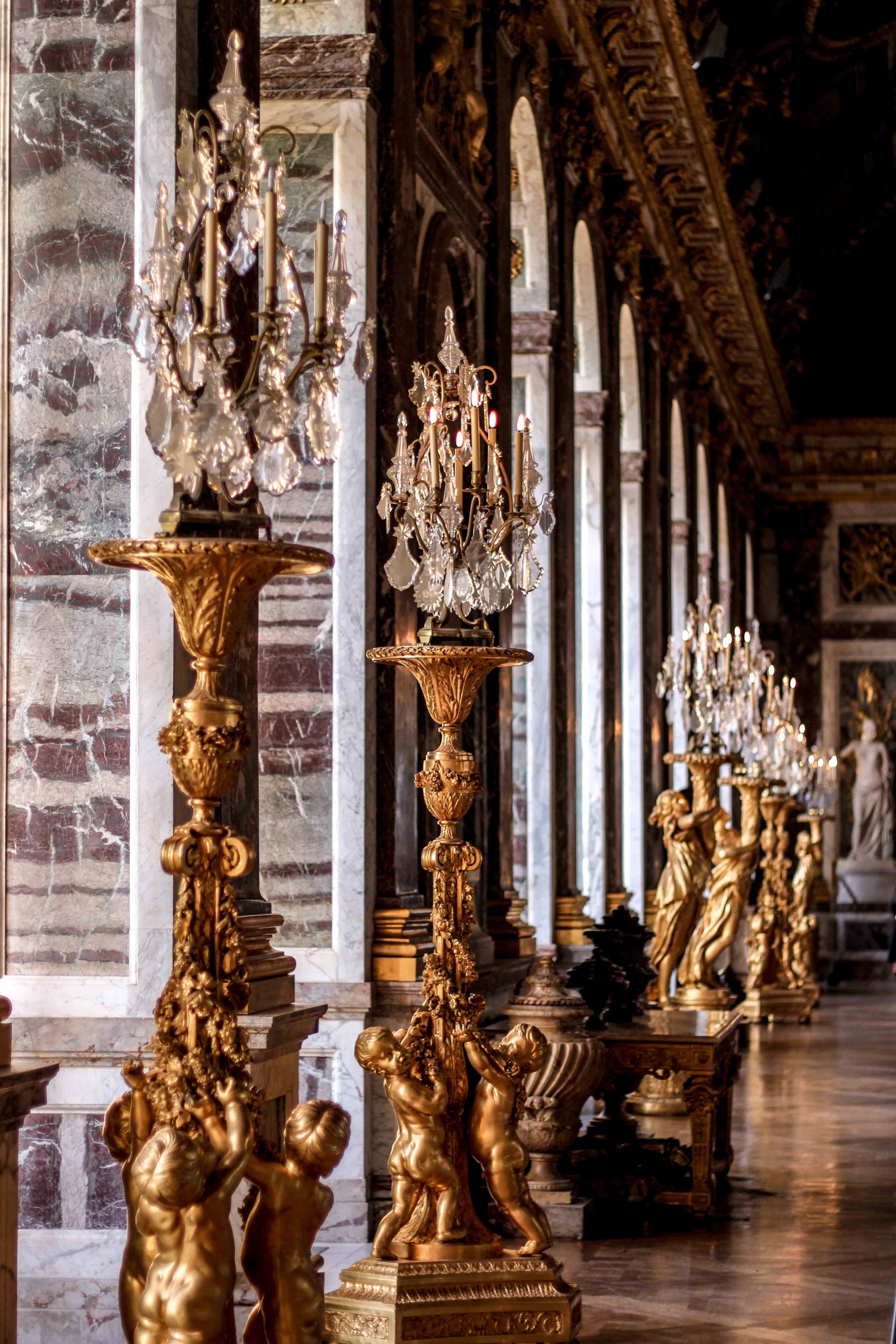 A room with many gold statues and chandeliers - Royalcore