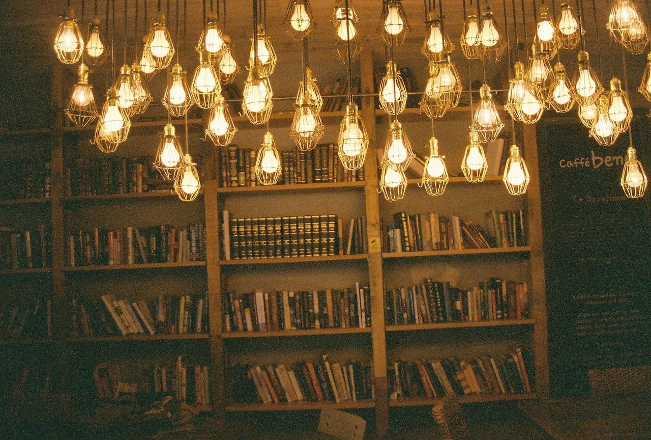 A room with many books and light bulbs - Royalcore