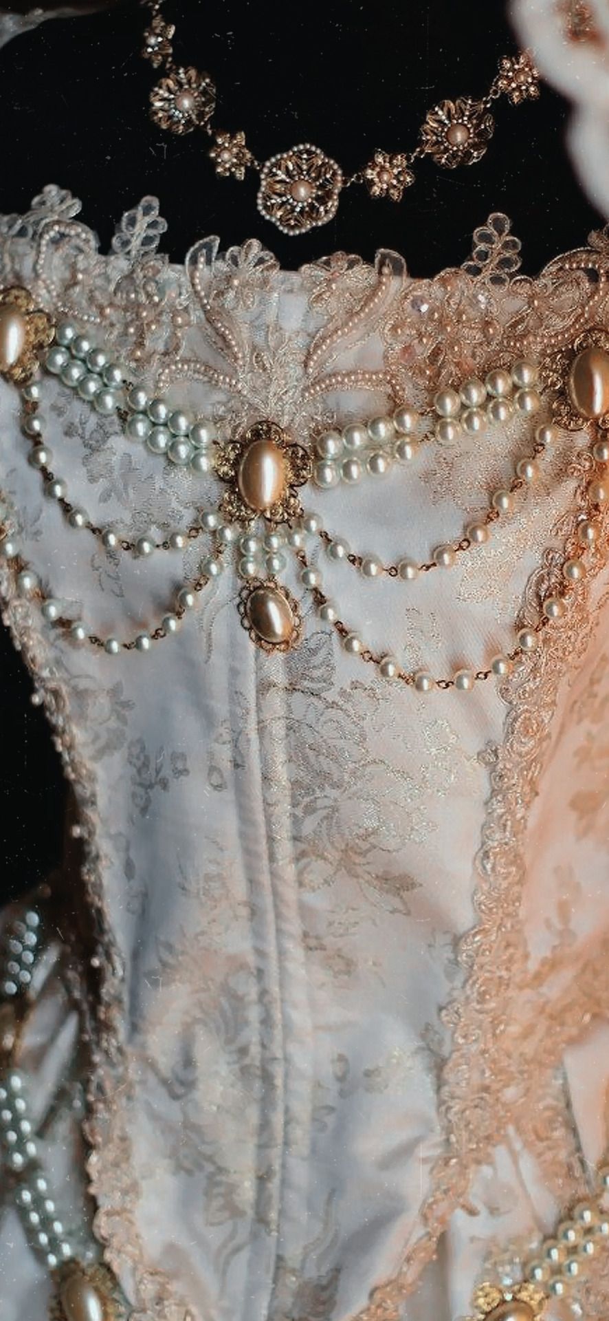 Close up of a white corset with gold and pearl details - Royalcore