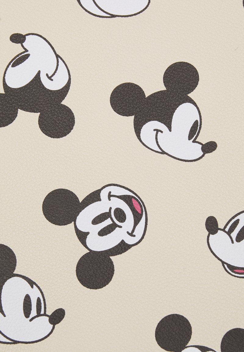 A close up of mickey mouse faces on beige fabric - Mickey Mouse
