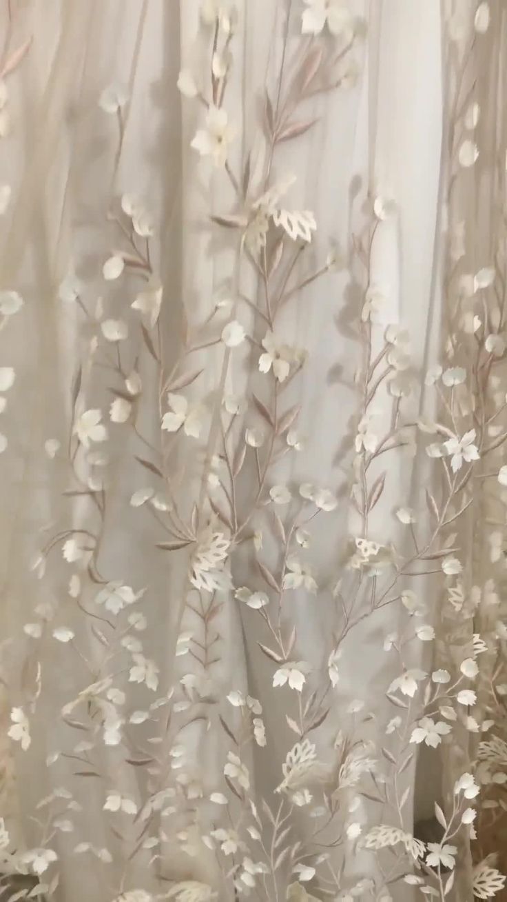 A close up of a white curtain with flowers on it - Wedding