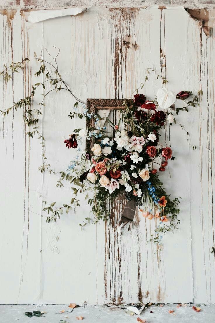 A floral arrangement is displayed on the wall - Wedding